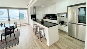 A modern kitchen with a central island, bar stools, and stainless steel appliances. - Santa Ana Guayaquil Lux Coliving Ecuador (Guayaquil)