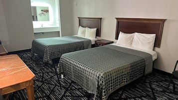 Habitación de hotel con dos camas, una mesita y un ventanal.