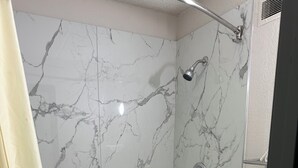 Ein Badezimmer mit Badewanne, Dusche und Toilette.