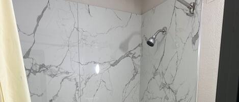 Un baño con bañera, ducha e inodoro.
