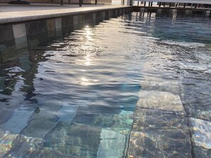 A clear pool with sunlight reflecting off the water's surface. - Casa Santa Giulia (Propriano)