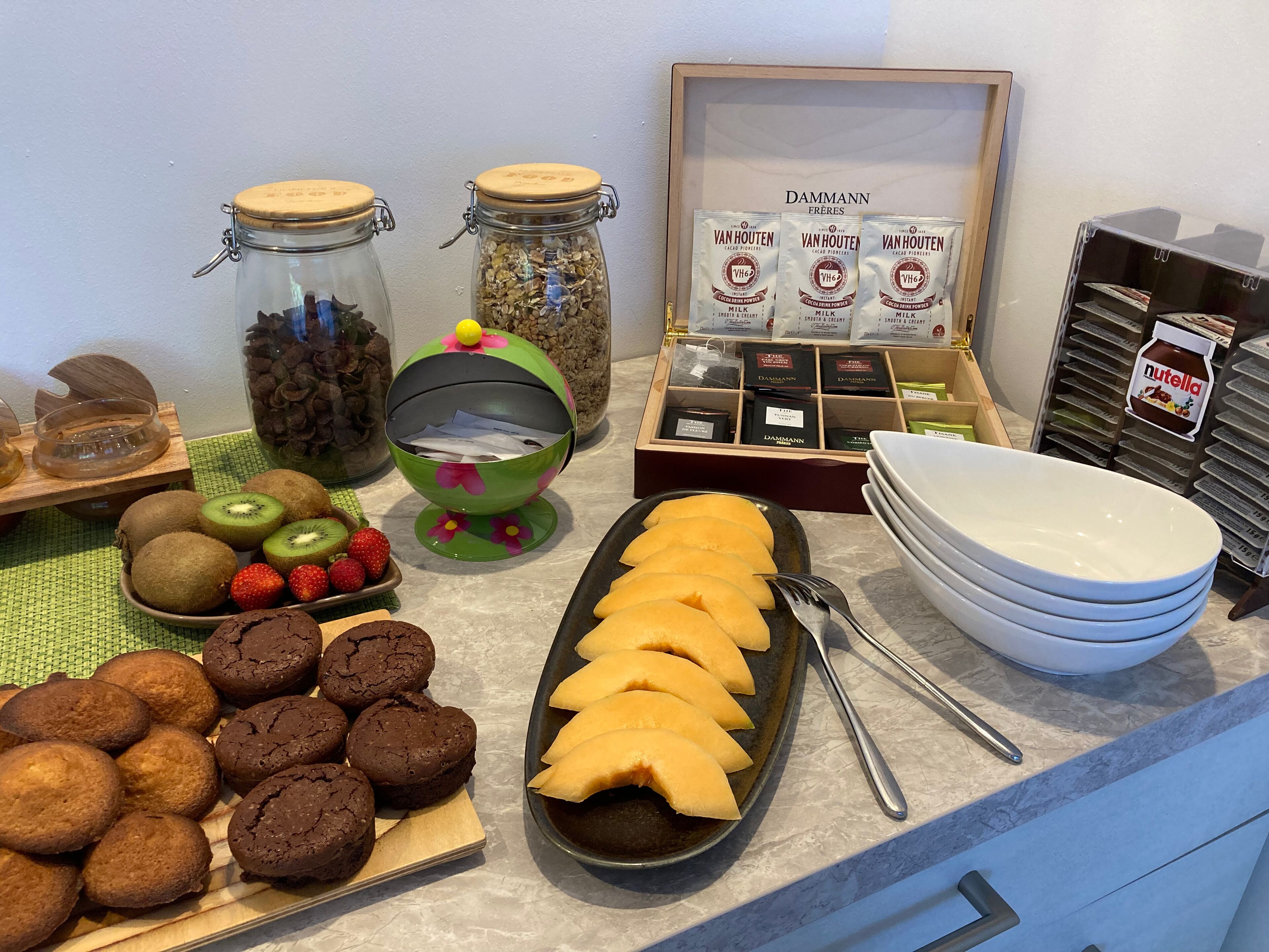 Een ontbijtbuffet met diverse producten, waaronder koekjes, fruit en zuivel.