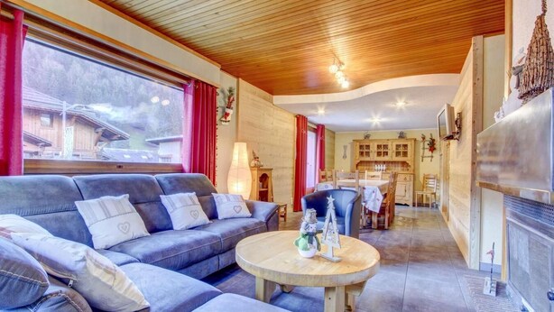 A cozy living room with a sofa, a round coffee table, and a fireplace. - 1st floor, view ski slopes, balcony, fireplace or stove, parking, tv, 118m², Morzine (Morzine)