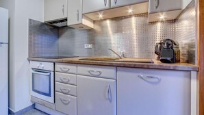 A modern kitchen with stainless steel appliances, a wooden countertop, and a dot-patterned backsplash. - 1st floor, view ski slopes, balcony, fireplace or stove, parking, tv, 118m², Morzine (Morzine)