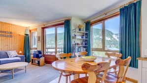 A cozy room with a wooden dining table, chairs, a sofa, and a TV. - 50m from ski slopes, 2nd floor, view mountain, balcony, tv, ski locker, 38m², Morzine (Morzine)