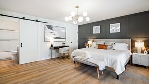 A modern bedroom with a large bed, bedside tables, a desk, and a chair. - 6Beds 3Bath - Pool, Hot Tub, Pets Welcome, Fire Pit- 1mi to Downtown (Healdsburg)