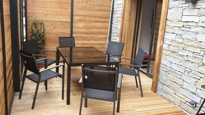 A modern outdoor seating area with a wooden table and four chairs. - 100m from ski slopes, Ground floor, terrace, parking, tv, 31m², Morzine (Morzine)
