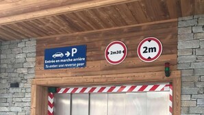 An elevator entrance with a sign indicating a 2-meter height limit and a parking sign above. - 100m from ski slopes, Ground floor, terrace, parking, tv, 31m², Morzine (Morzine)
