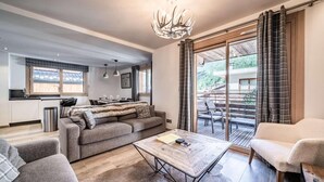Een moderne woonkamer met een bank, een salontafel en een eethoek met een tafel en stoelen.