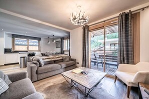 A modern living room with a sofa, a coffee table, and a dining area with a table and chairs. - 20m from resort center, 1st floor, balcony, parking, tv, 89m², Morzine (Morzine)
