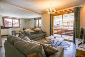 A modern living room with a sofa set, a coffee table, and a chandelier. - 100m from ski slopes, 1st floor, balcony, parking, tv, 86m², Morzine (Morzine)