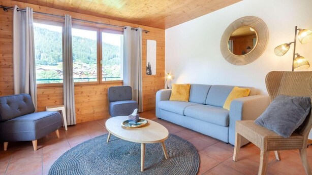 A cozy room with a sofa, armchair, and a round coffee table. - Ground floor, view mountain, balcony, parking, tv, 64m², Morzine (Morzine)