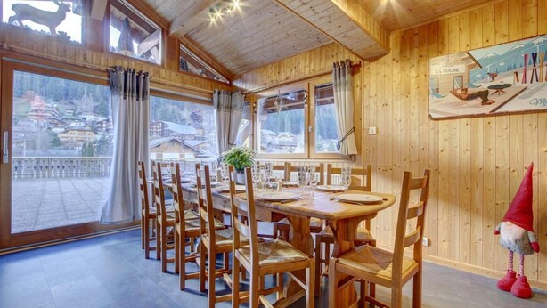 A dining area with wooden furniture, large windows, and a view of a snowy landscape. - 1st floor, view mountain, terrace, parking, tv, 160m², Morzine (Morzine)