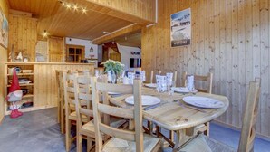 A wooden interior with a dining area set for four, featuring wooden tables and chairs, a kitchen area, and a sign indicating 'MORZINE'. - 1st floor, view mountain, terrace, parking, tv, 160m², Morzine (Morzine)