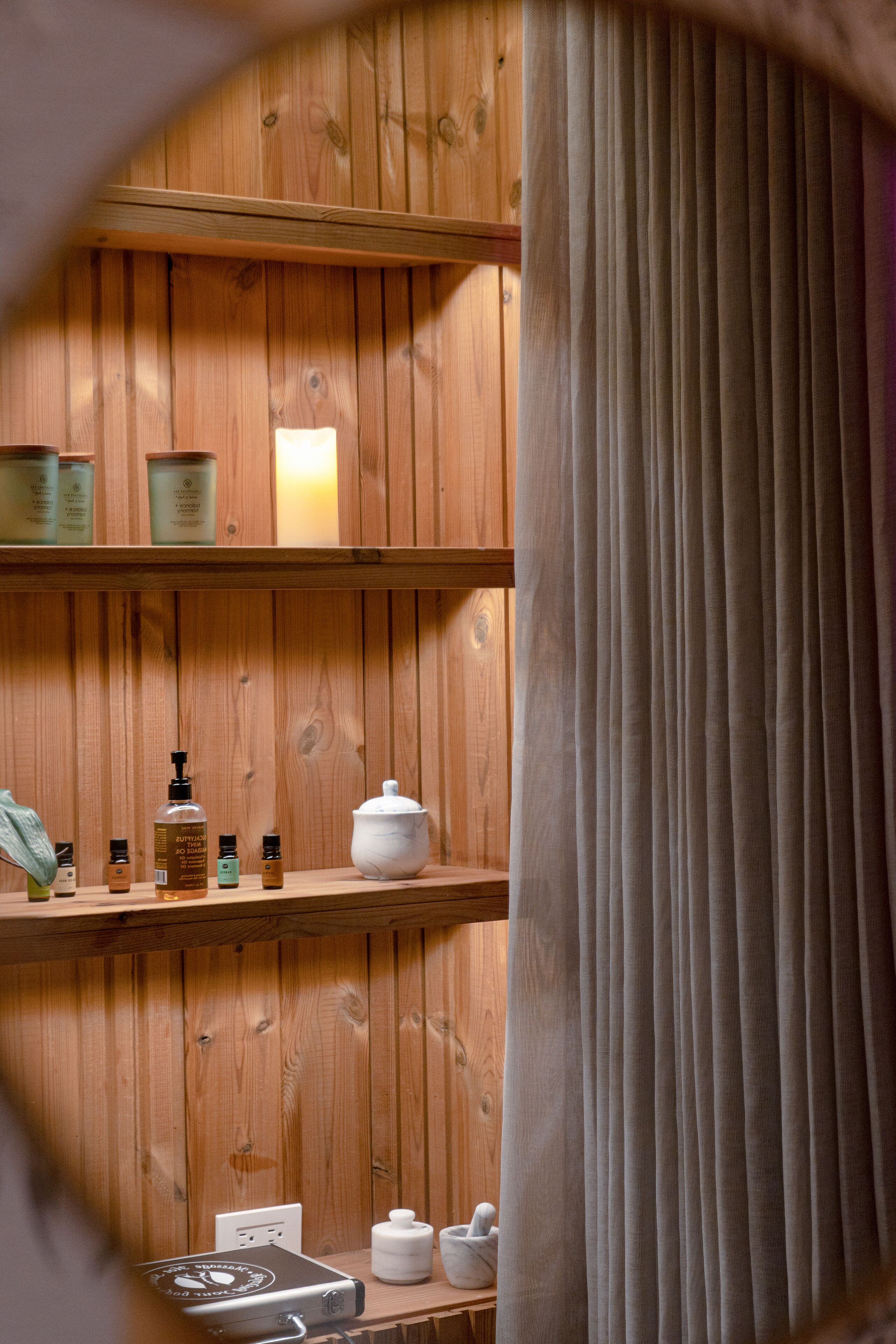 A wooden shelf with toiletries and a white pot.