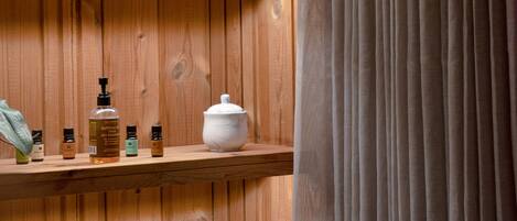 A wooden shelf with toiletries and a white pot.