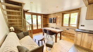 Un interior moderno con una escalera de madera, un comedor y una cocina.