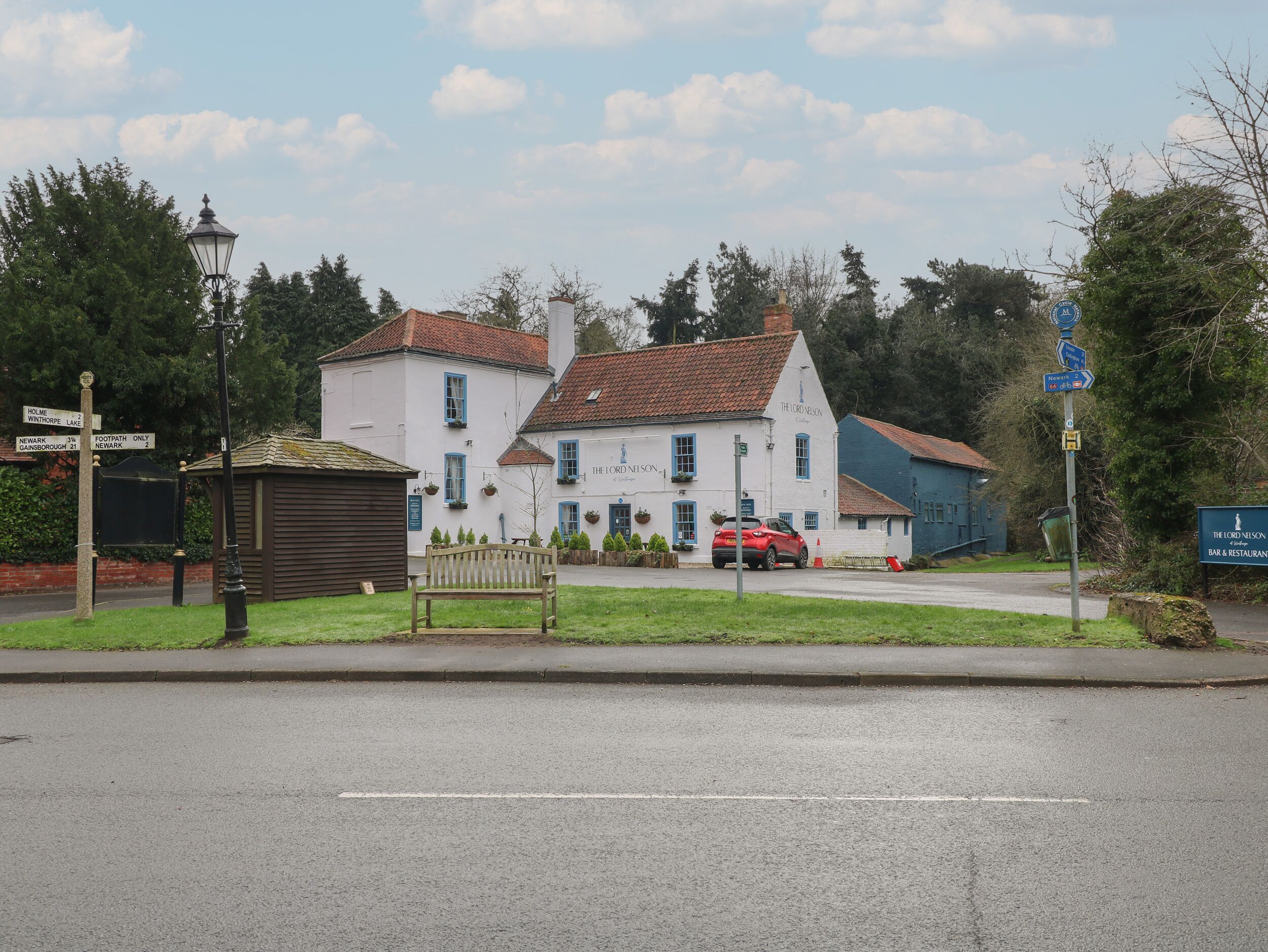 Un edificio de dos pisos con fachada blanca y detalles azules, que dice "The Lord Nelson".