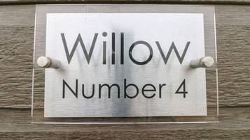 Una señal con el texto 'Willow Number 4' fijada a una pared con textura.