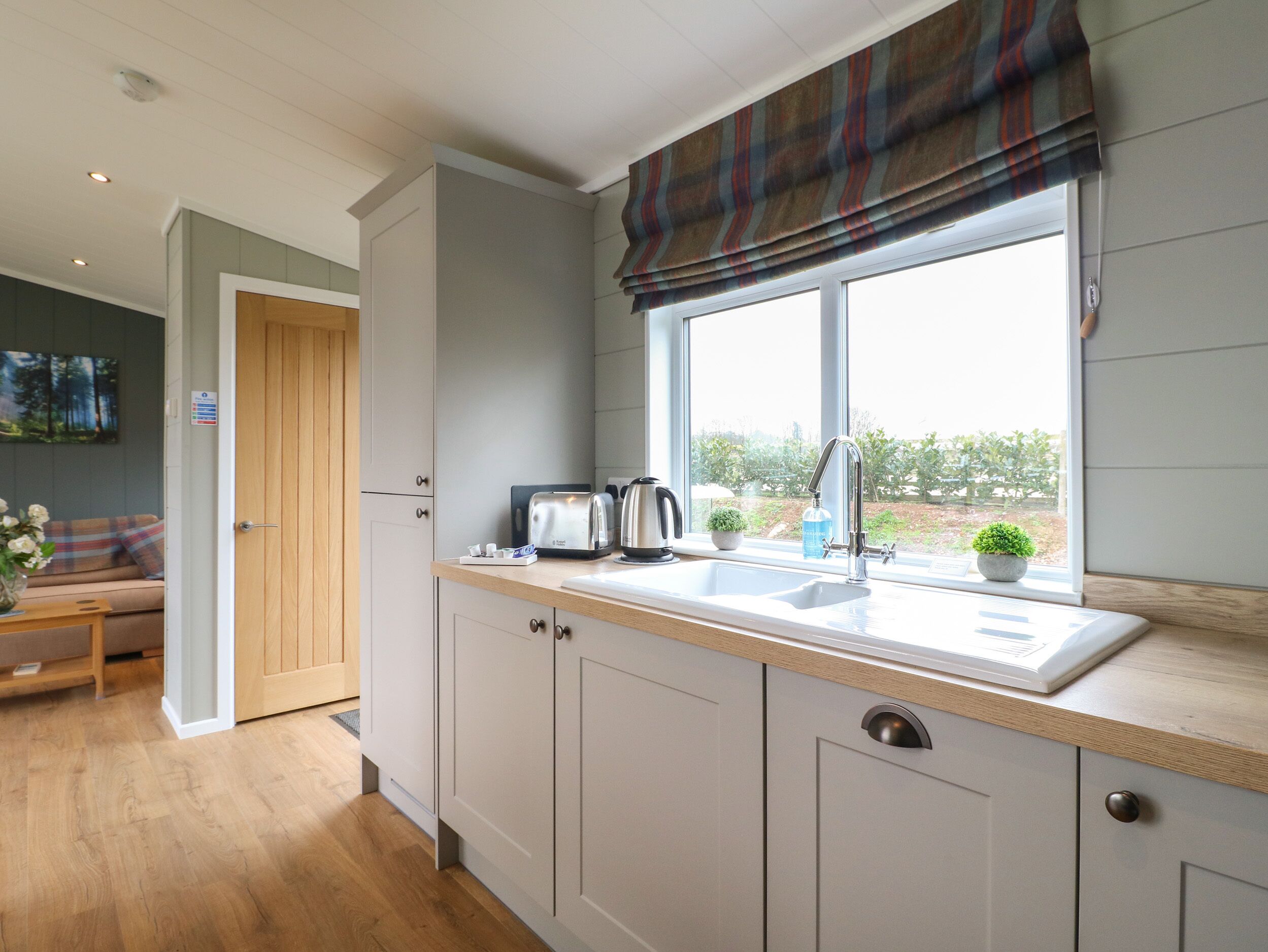 A modern kitchen with a window, a sink, and a toaster.