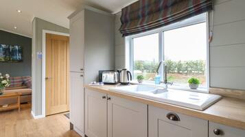 A modern kitchen with a window, a sink, and a toaster.