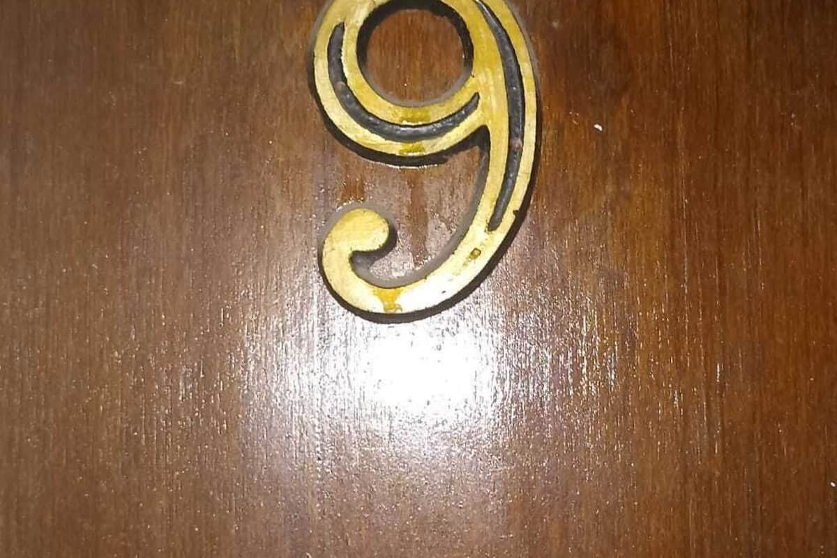 A wooden surface with a brass number '9' inlay.