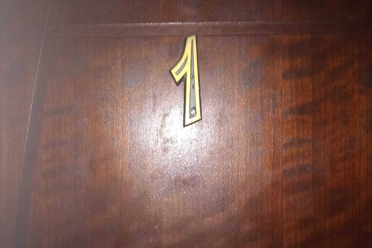 A wooden surface with a brass number '1' prominently displayed.