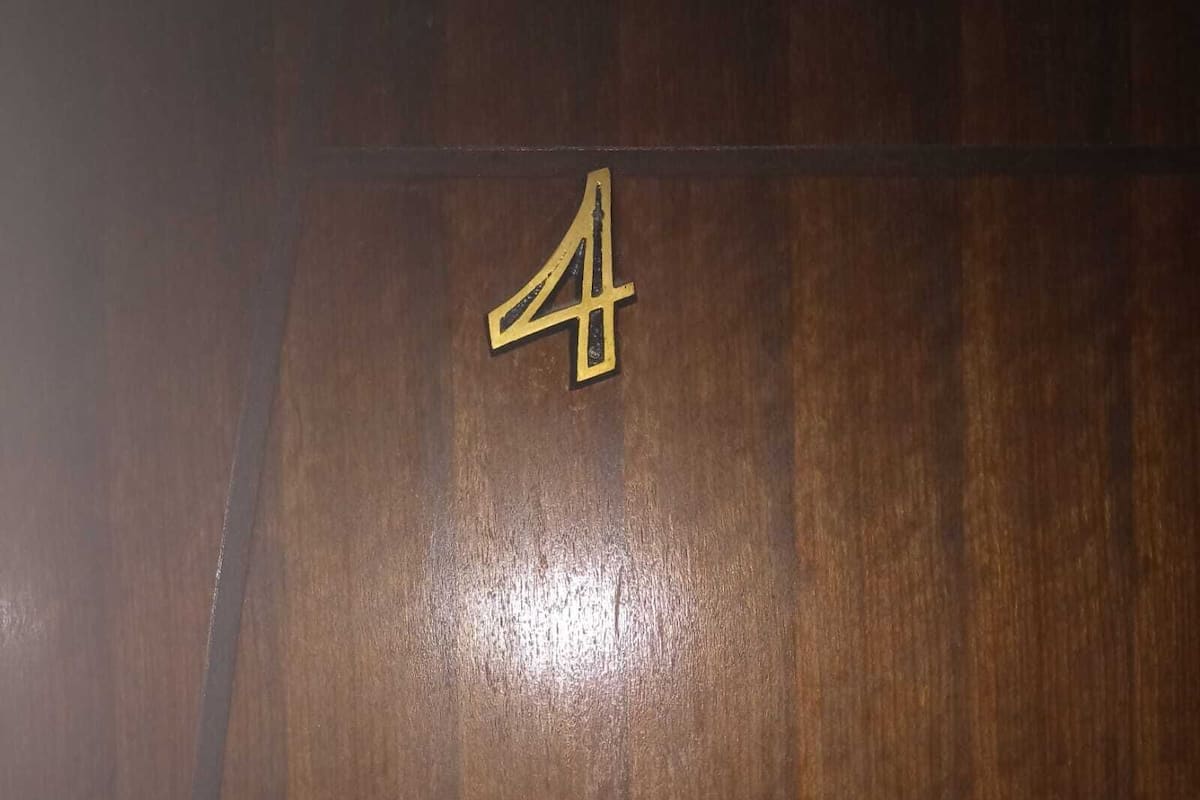 A wooden floor with a brass number '4' sign.