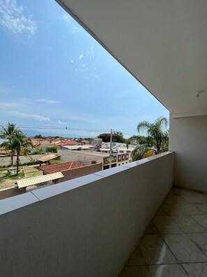 Un balcon donnant sur un quartier résidentiel, avec vue sur les maisons et la végétation.