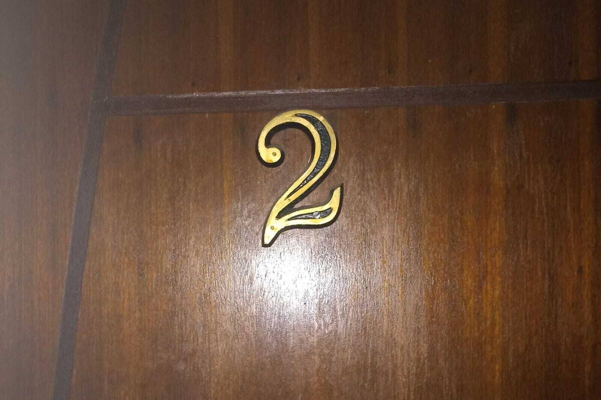 A wooden floor with a brass number "2" indicating room number.