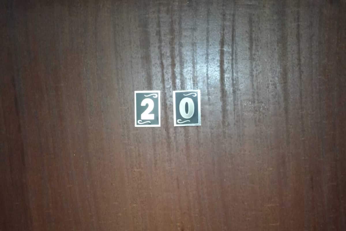 A wooden surface with two stickers, one with the number 2 and the other with the number 0.