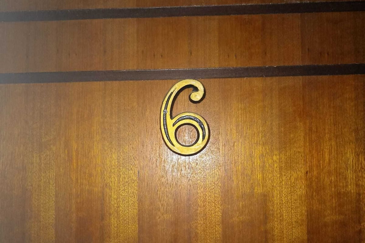 A wooden surface with a large, gold-colored number '6' prominently displayed.