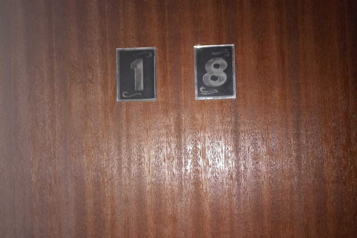 Two numbered plaques on a wooden surface, indicating room numbers 1 and 8.