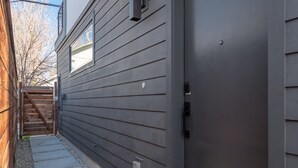 A modern building with horizontal siding, a metal door, and a small window. - Pura Vida House - 2 King Bed - Entire Home (Sacramento)