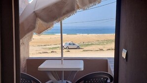A balcony with a view of a beach and a parked car.