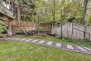 A backyard with a wooden deck, a stone pathway, and a wooden fence. - Lovely Salt Lake City Cottage w/ Outdoor Space! (Salt Lake City)