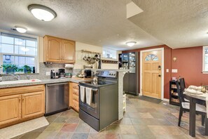 A kitchen with granite countertops, wooden cabinets, a stainless steel range, and a built-in oven. - Lovely Salt Lake City Cottage w/ Outdoor Space! (Salt Lake City)