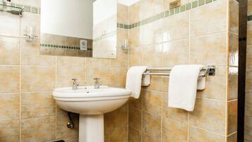 A bathroom with a white sink, mirror, and towel rack.