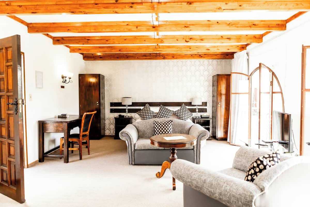 Ein Wohnzimmer mit Holzboden, einer Couch, einem Tisch und einem Fernseher.