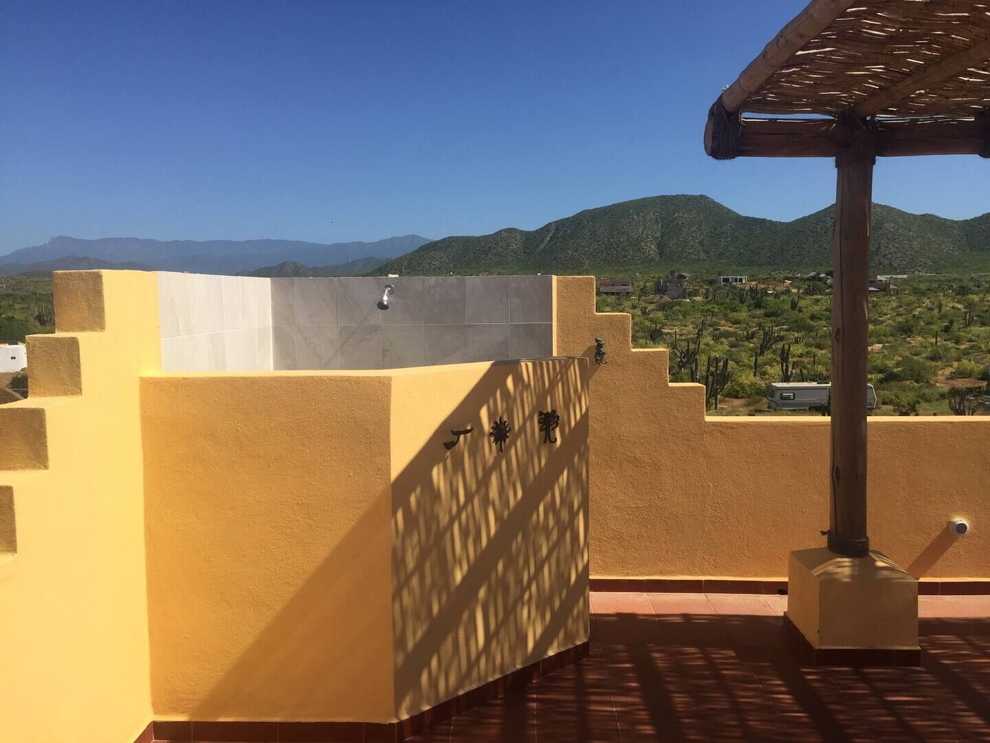 Una terraza en la azotea con vistas a montañas y un paisaje desértico.