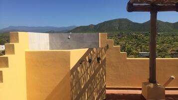 Una terraza en la azotea con vistas a montañas y un paisaje desértico.