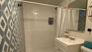 Un baño con ducha, inodoro y lavabo.