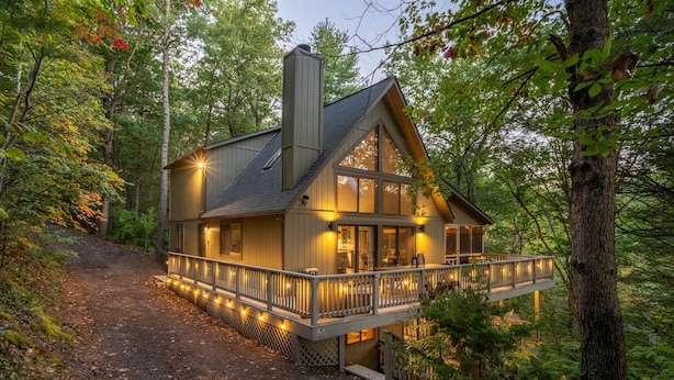 A cabin with a balcony, surrounded by trees. - Bryce Resort | Hot Tub | Game Room | Sleeps 12 (Basye)