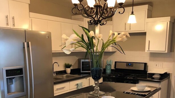 A modern kitchen with a central island, stainless steel appliances, and a chandelier. - ⭐️⭐️⭐️La Casita El Paso West side Buena Vista (El Paso)