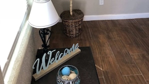 A room with a potted tree, a lamp, a welcome sign, and a decorative bowl on a mat. - ⭐️⭐️⭐️La Casita El Paso West side Buena Vista (El Paso)