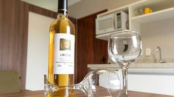 Une bouteille de vin Intis Sauvignon Blanc et un verre à vin sur une table en bois dans une cuisine.