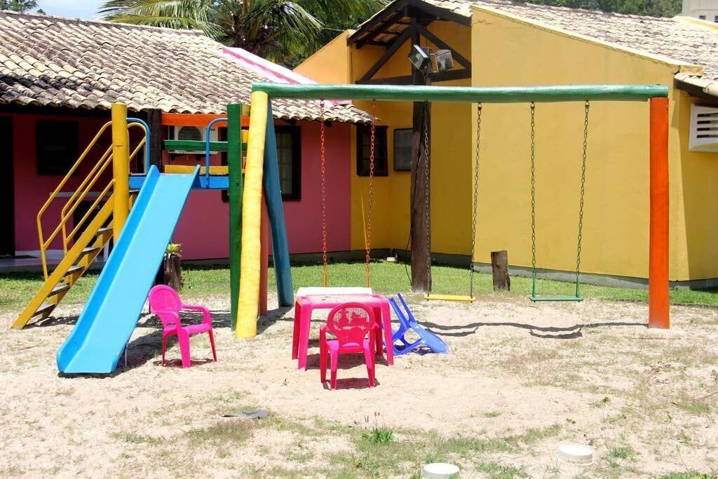 A playground with a slide, swings, and a small table.