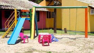 A playground with a slide, swings, and a small table.