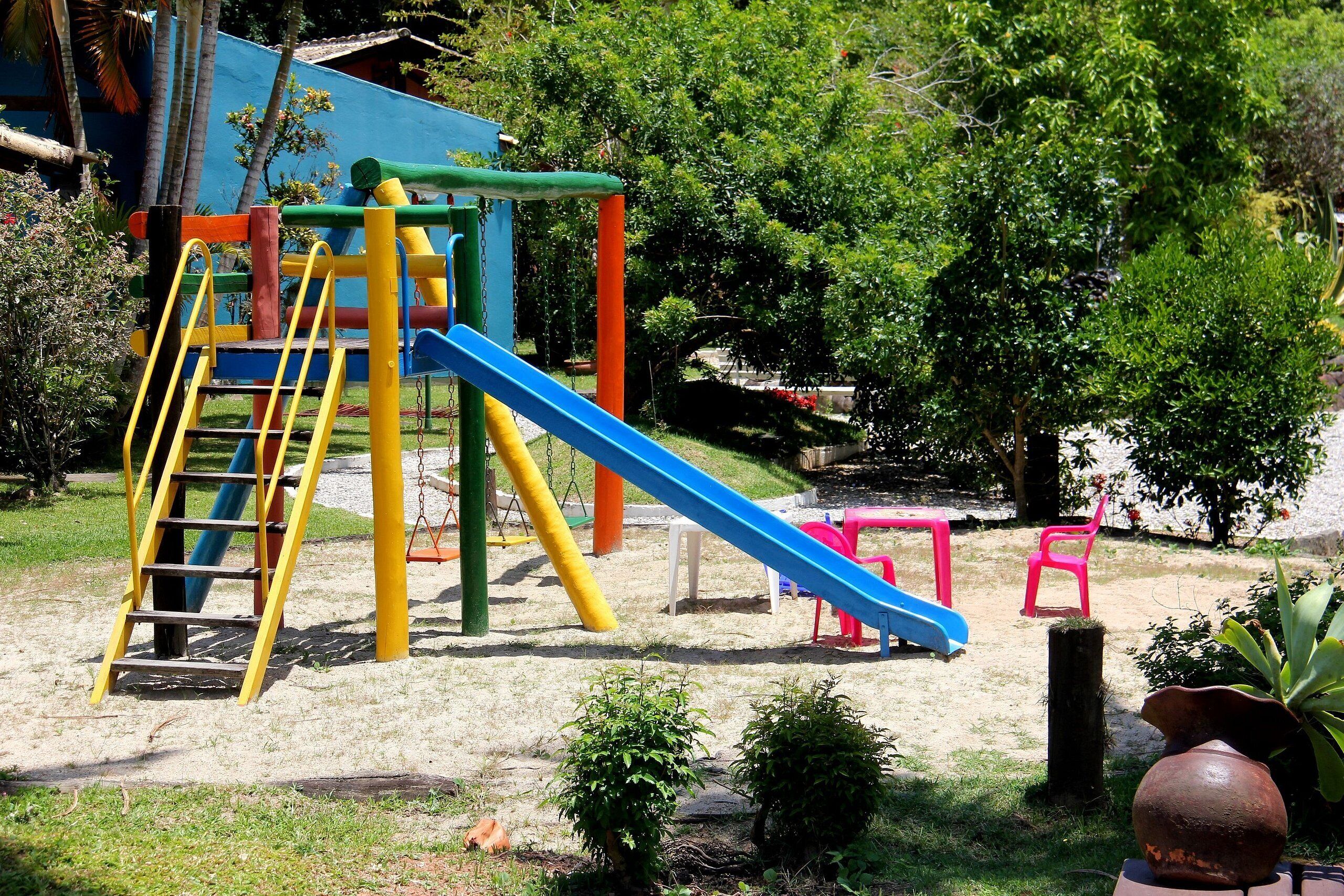 Un parque infantil con un tobogán y estructuras para escalar.