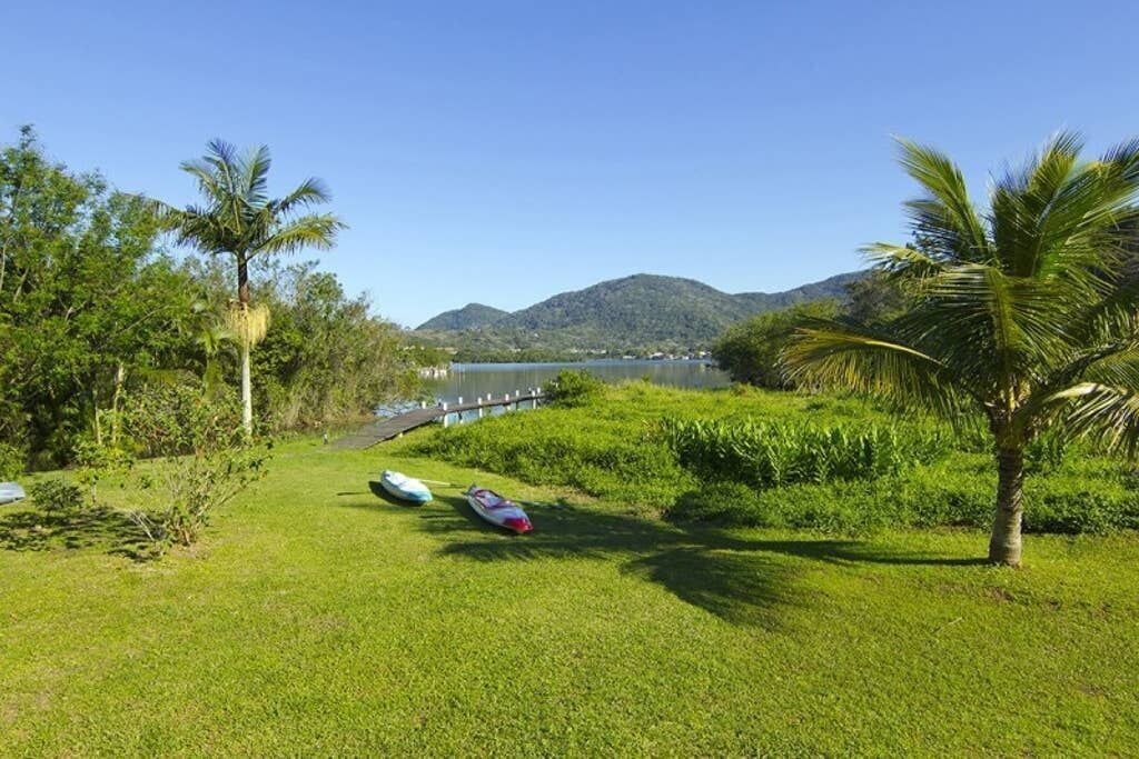 A grassy area with a water body and hills in the background.